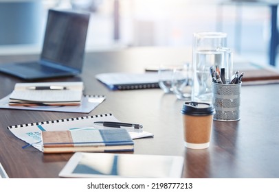 Desk, Empty Office Workspace On A Wooden Desk Or Table In A Corporate Boardroom. Laptop Or Computer In A Digital Marketing Agency Or IT Company With Notebooks And A Coffee Cup