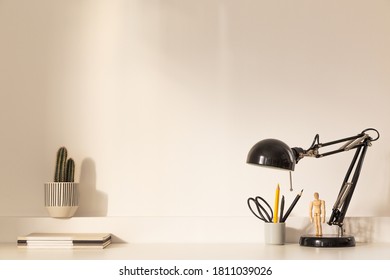 Desk at home office with lamp, books, cactus plant. golden hour. - Shutterstock ID 1811039026
