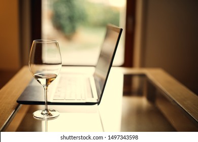 Desk Laptop with wineglass, home office, work in the evenings