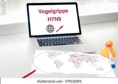 Desk With Laptop World Map Medical Thermometer And Rubber Duck. Several Countries Are Marked On The Map Indicating Bird Flu Outbreak Regions. The Screen Shows Avian Influenza Medical Terms