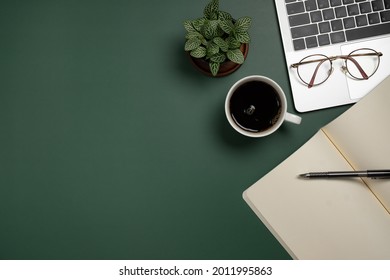 Desk office with blank notepad, coffee cup, glasses and pen on green table. Flat lay top view copy space. Home office. - Shutterstock ID 2011995863