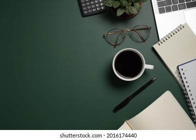 Desk office with laptop, blank notepad, coffee, flower, coffee cup, calculator and pen on green table. Flat lay top view copy space. Home office. - Shutterstock ID 2016174440