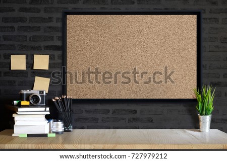 Desk space concept. Mock up Cork board, vintage camera and films on wood table workplace with supplies. 