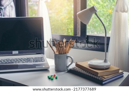 Desk for student concept. Laptop Computer for study for exam, book, lamp place on School table for student work online at home. 