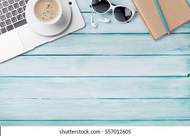 Desk table with laptop, coffee and sunglasses on wooden table. Workplace. Top view with copy space. - Powered by Shutterstock