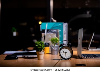 Desk Table At Night With Analog Clock , In Overtime Work Or Work Late Night Office Concept With Copy Space