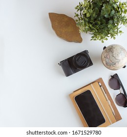 Desk top with a camera, globe and notebook. 
