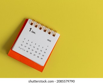 Desktop calendar for January 2022 on a yellow background. - Shutterstock ID 2085579790