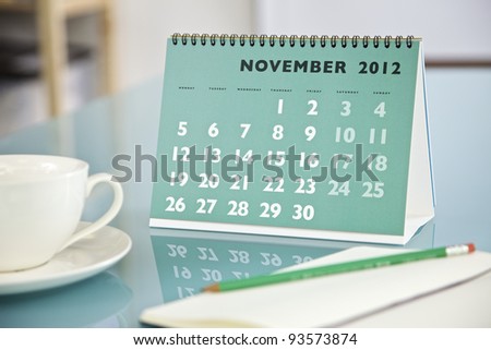 Desktop calendar sitting on a glass desk showing the month of November 2012