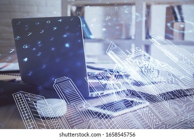 Desktop computer background in office and big town buildings hologram drawing. Double exposure. Smart city concept.