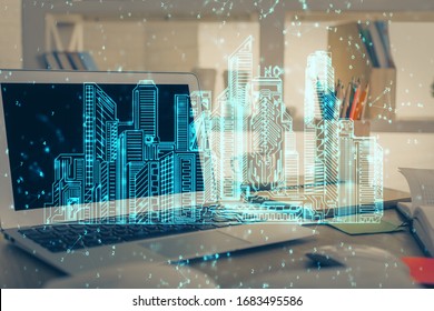 Desktop computer background in office and big town buildings hologram drawing. Double exposure. Smart city concept.