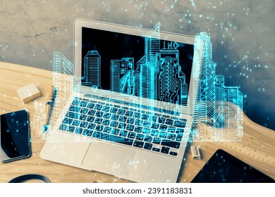 Desktop computer background in office and big town buildings hologram drawing. Double exposure. Smart city concept.