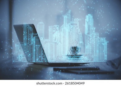 Desktop computer background in office and big town buildings hologram drawing. Double exposure. Smart city concept.