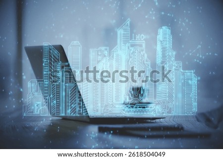 Desktop computer background in office and big town buildings hologram drawing. Double exposure. Smart city concept.