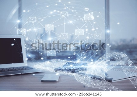 Desktop computer background in office and flying envelops hologram drawing. Double exposure. Electronic mail concept.