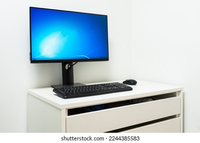 Desktop computer on white table in white walled room