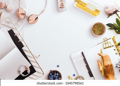 Desktop Flatlay Scene, With White Open Planner, Desk Tidy Tray, Gold And Rose Gold Stationery Accessories, Jewellery, Pink Peony, Featuring A Female Hand Holding A Gold Pen