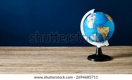 Desktop Globe Model on Rustic Wooden Table with Deep Blue Background
