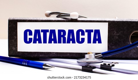 The Desktop Has A Stethoscope, A Blue Pen, And A Gray File Folder With The Text CATARACT. Medical Concept