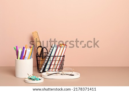 Desktop organizer with school stationary and office supplies over pastel background. Back to school, home office, begining of studies concept