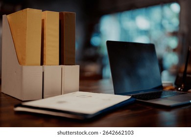 Desktop view with file holders, documents, and a laptop, representing structured office work and document management.