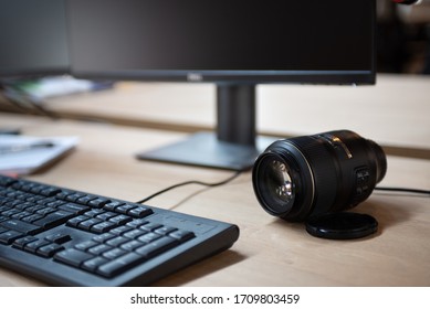 Desktop view, two computer screens, keyboard, mouse and computer have a blank black screen on a wooden desk and an office background