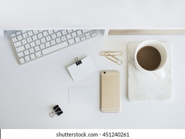 Desktop Workplace Top View. Modern Trend Template For Advertising, Product Mock Up. Presentation Template. Coffee, Keyboard, Business Cards, Phone. White And Gold. Minimalistic Desk Set. Flatlay