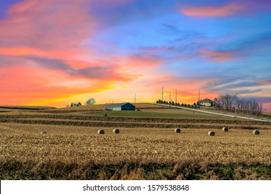 A Desolate Corn Field In The Middle Of Iowa Under A Orange Yellow Painted Sky. 