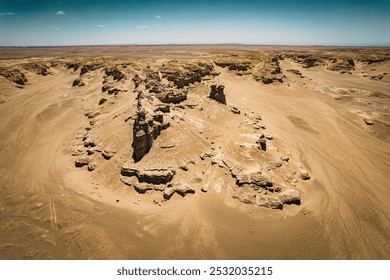 Desolate terrain under bright sky with rugged rock formations and scattered shadows in a stark, arid landscape. - Powered by Shutterstock