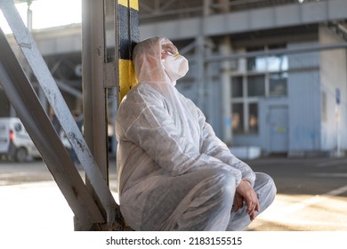 Despair Healthcare Worker In White Covid Protective Overalls.Tired Male Caucasian Doctor In Depression During Coronavirus Pandemic Paramedic Overworked Cry Covered Face With Hands