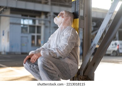 Despair Healthcare Worker In White Covid Protective Overalls.Tired Male Caucasian Doctor In Depression During Coronavirus Pandemic Paramedic Overworked Cry Covered Face With Hands