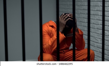 Desperate black prisoner sitting in cell, wrongly accused person, faulty system