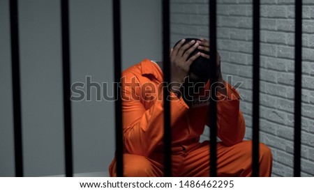 Desperate black prisoner sitting in cell, wrongly accused person, faulty system
