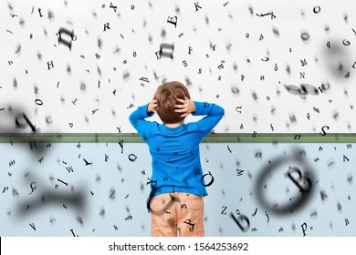 Desperate Child With Dyslexia In Front Of A Whiteboard With Flying Letters At School