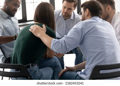 Desperate crying girl sharing sad experience with group mates on psychological support meeting. Diverse team of counselor patients giving help and comfort to depressed member. Mental health concept