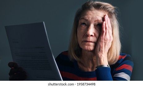 Desperate Elderly Woman Reading Eviction Notice. High Quality Photo