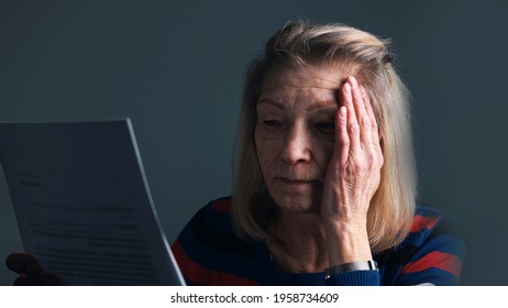 Desperate Elderly Woman Reading Eviction Notice. High Quality Photo