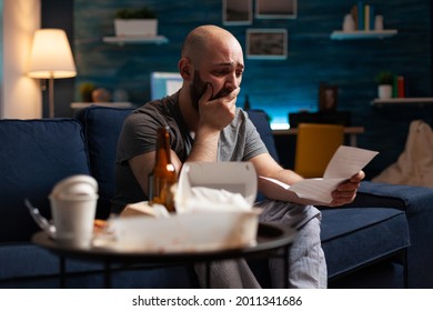 Desperate Frustrated Stressed Young Man Reading Letter, Payment Debt Notification, Bad Financial Report, Eviction Renter Notice. Anxious, Worried Tenant By Warning Document For Unpaid Bank Bills