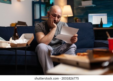 Desperate Frustrated Stressed Young Man Reading Letter, Payment Debt Notification, Bad Financial Report, Eviction Renter Notice. Anxious, Worried Tenant By Warning Document For Unpaid Bank Bills