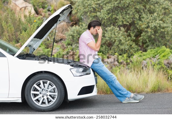 Desperate man after a car breakdown at the side of\
the road