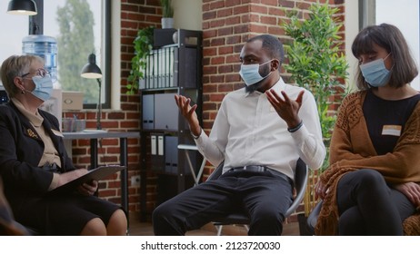 Desperate Man Sharing Addiction Issues With Group And Counselor At Aa Therapy Session, Wearing Face Mask. Adult Having Depression And Mental Health Problems At Rehabilitation Meeting.