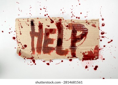 A desperate message with the word HELP written in blood on a piece of torn cardboard, surrounded by splatters. Ideal for horror, crime, and emergency concepts. Horror or Halloween background