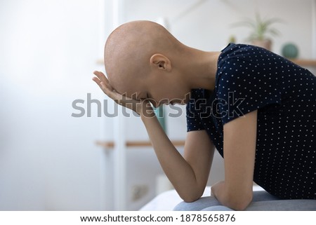 Desperate millennial female sick with cancer sit on bed unable to believe accept hard diagnosis. Depressed young woman oncology clinic patient feeling frustrated receiving bad test results. Copy space