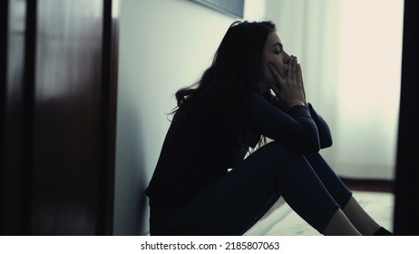 Desperate person in distress during emotional crisis. Woman sitting on floor at home feeling ashamed. Depressed girl alone