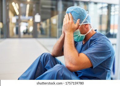 Desperate surgeon in blue surgical clothes with hands in front of the face - Shutterstock ID 1757159780