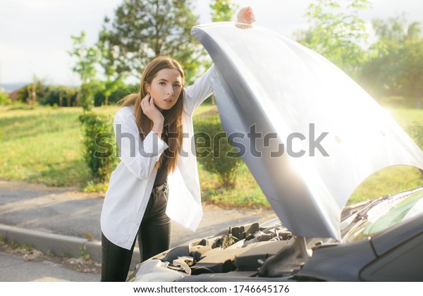 Desperate\
woman after checking her car broken\
engine