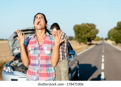 Desperate Woman Praying Desperately Because Of Car Problems. Despair Couple Waiting For Help After Engine Breakdown.