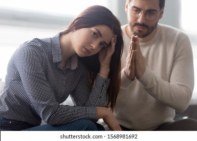 Desperate Young Husband Join Hands In Prayer Ask Millennial Upset Wife For Forgiveness After Fight, Caucasian Man Make Peace Reconcile With Offended Spouse, Beg Forgive Cheating, Relationship Problems