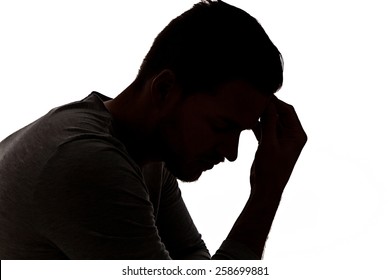 Desperate young man in silhouette holding his head - Powered by Shutterstock