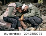 Despondent Arabian family sitting on ruins of house and hugging each other after hostilities, war concept